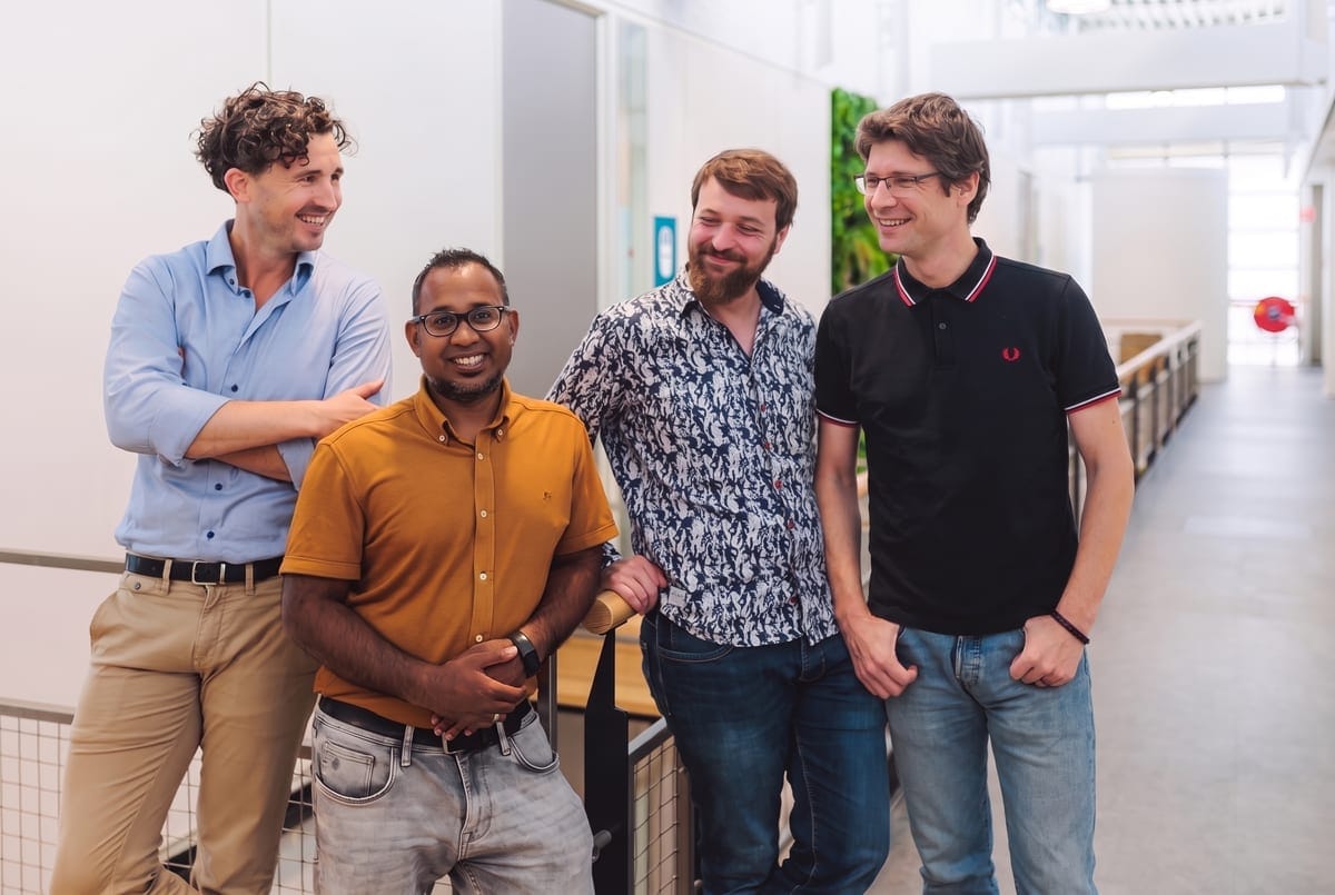 The And AI team: four colleagues laughing together in a bright office hallway